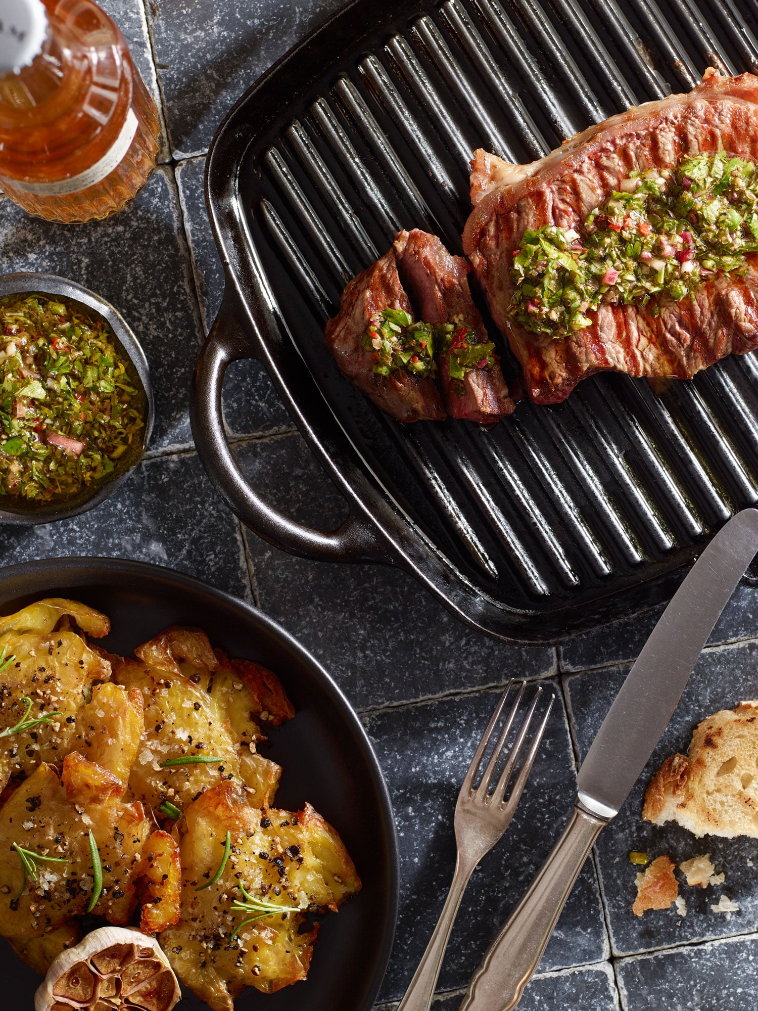 Gebratenes Rumpsteak in Grillpfanne, mit Chimichurri und Smashed Potatoes.