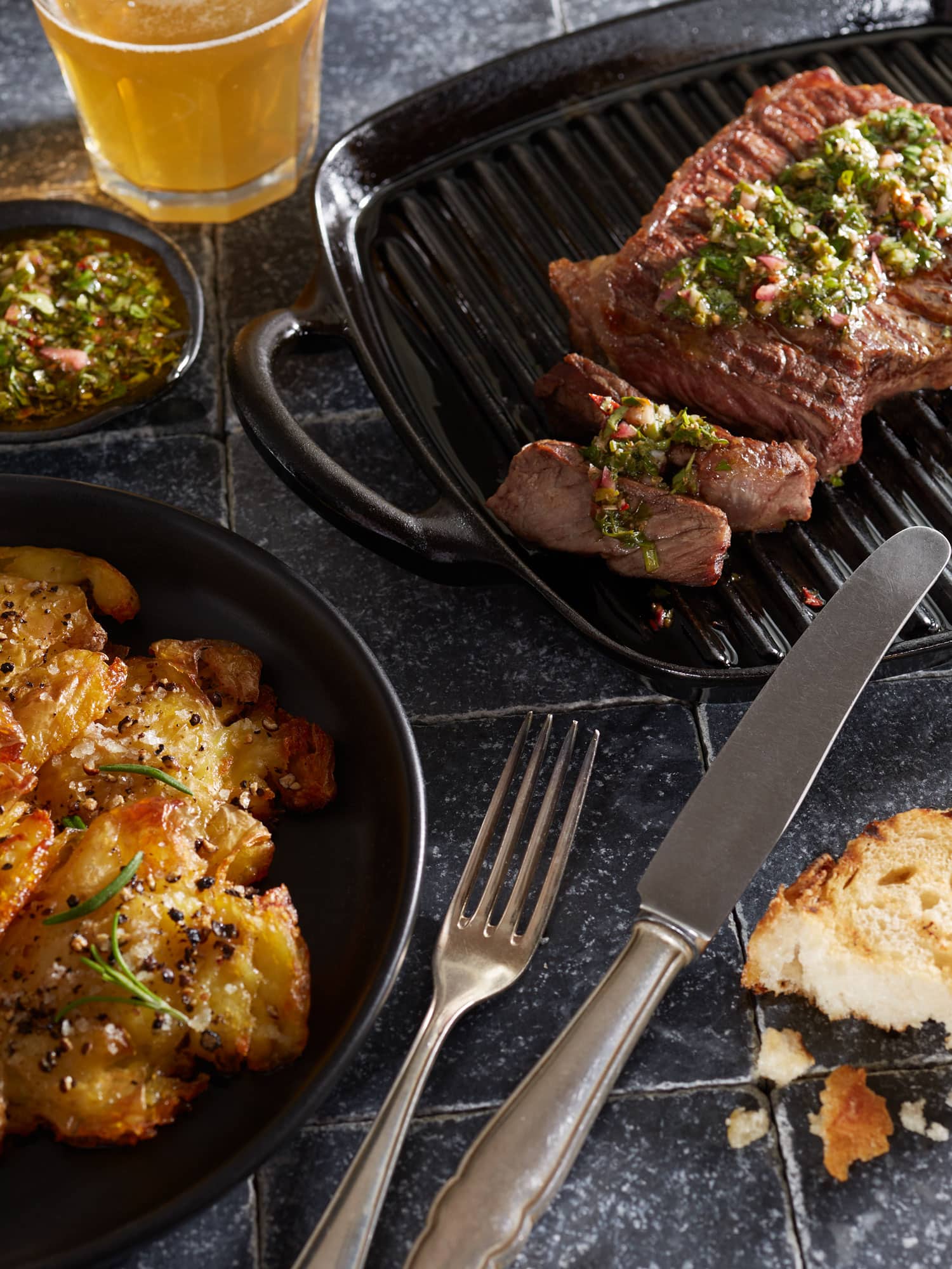 Rumpsteak in Grillpfanne mit Smashed Potatoes und Chimichurri Gewürzsauce.