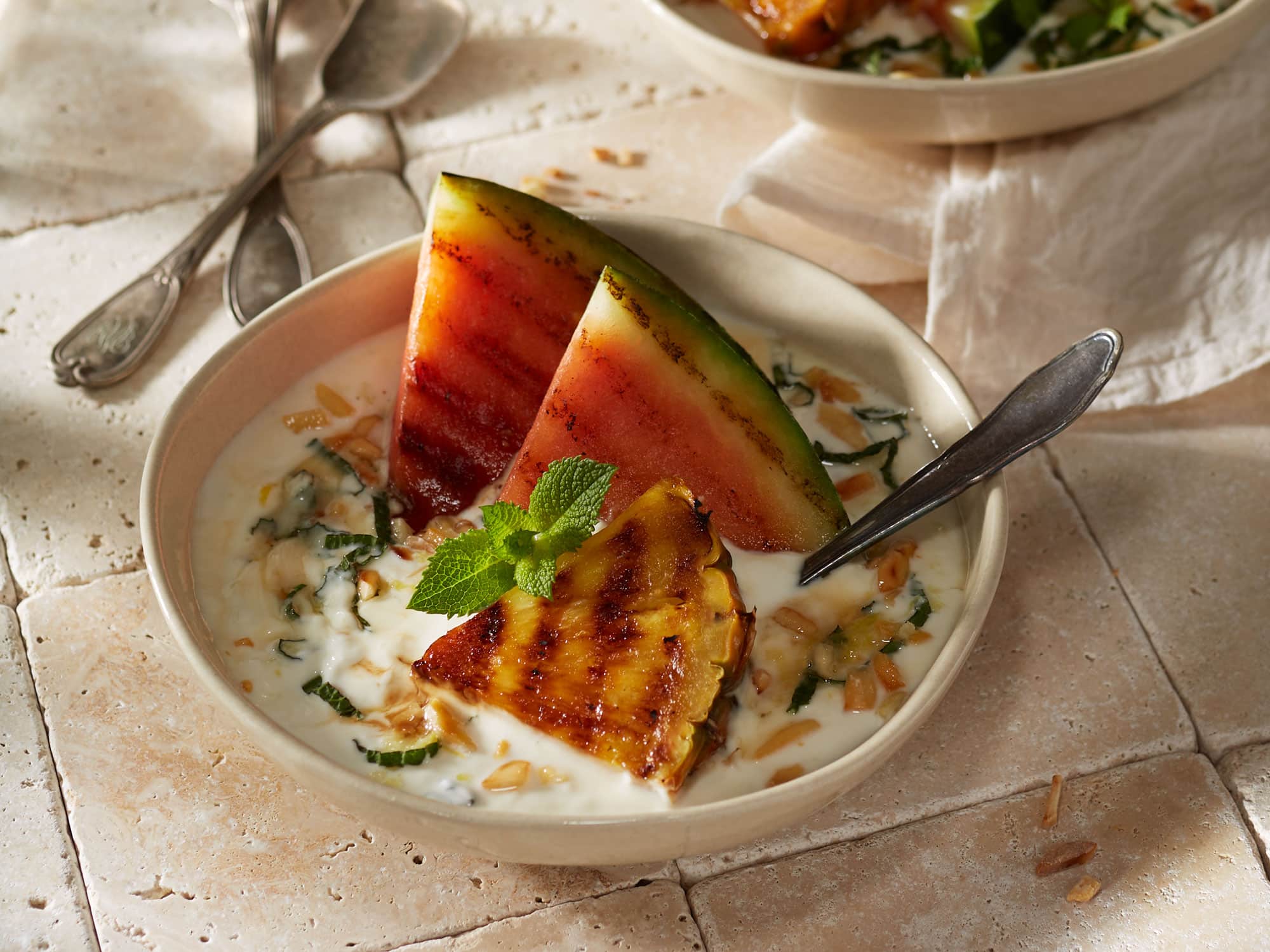 Joghurt mit gerösteten Mandeln, gegrillter Wassermelone, Ananas und frischer Minze.