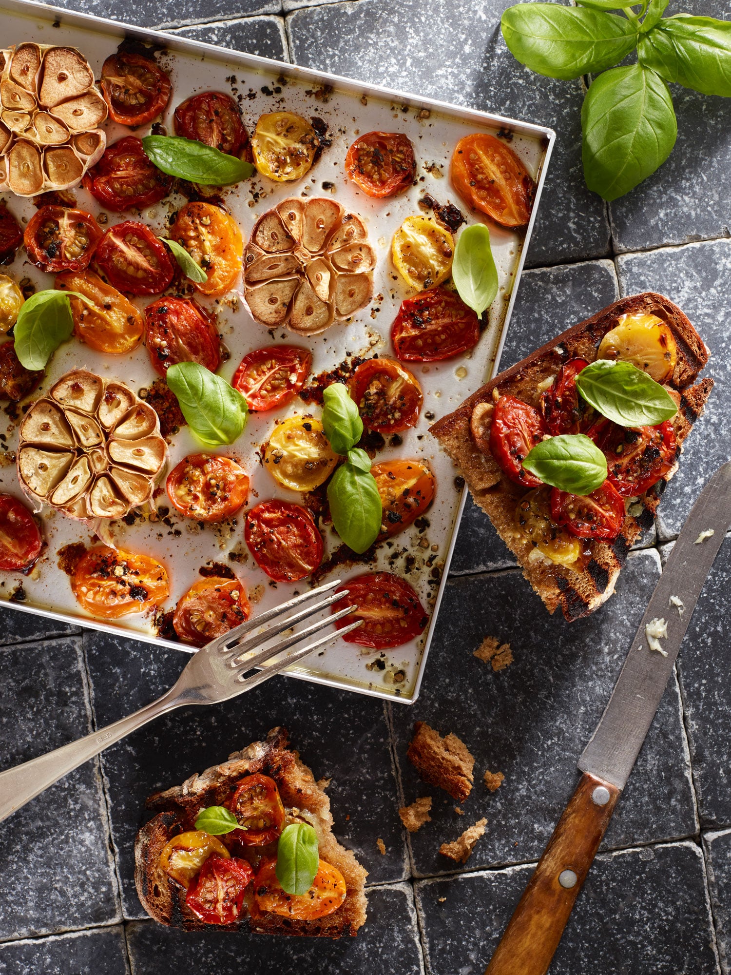 Ofentomaten mit Knoblauch, Basilikum und Schwarzbrot-Bruschetta.