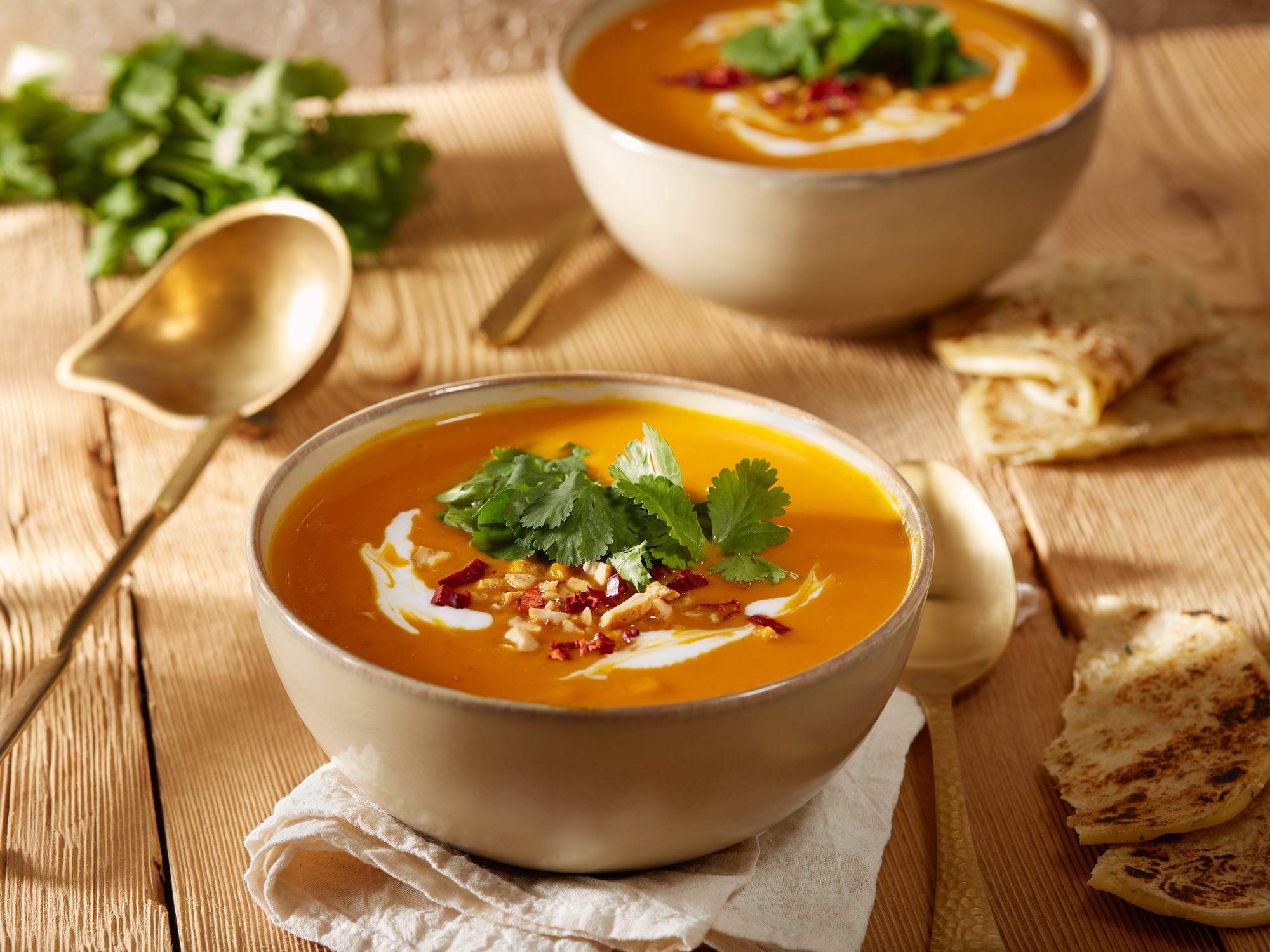 Asiatische Kürbissuppe mit Kokosmilch, Erdnuss-Chili Topping und frischem Fladenbrot.