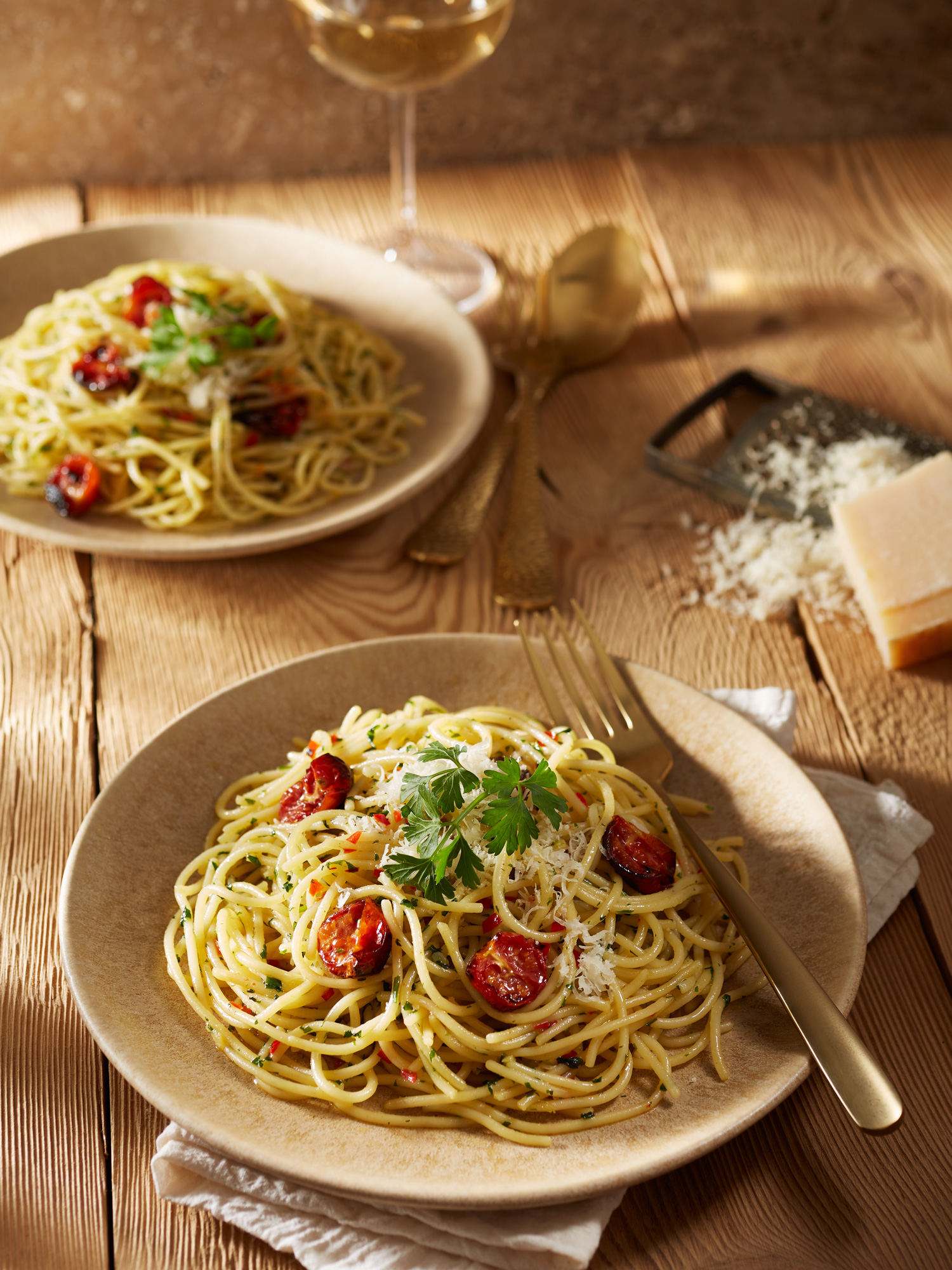 Spaghetti Aglio Olio e Peperoncino mit Ofentomaten und frischer Petersilie.