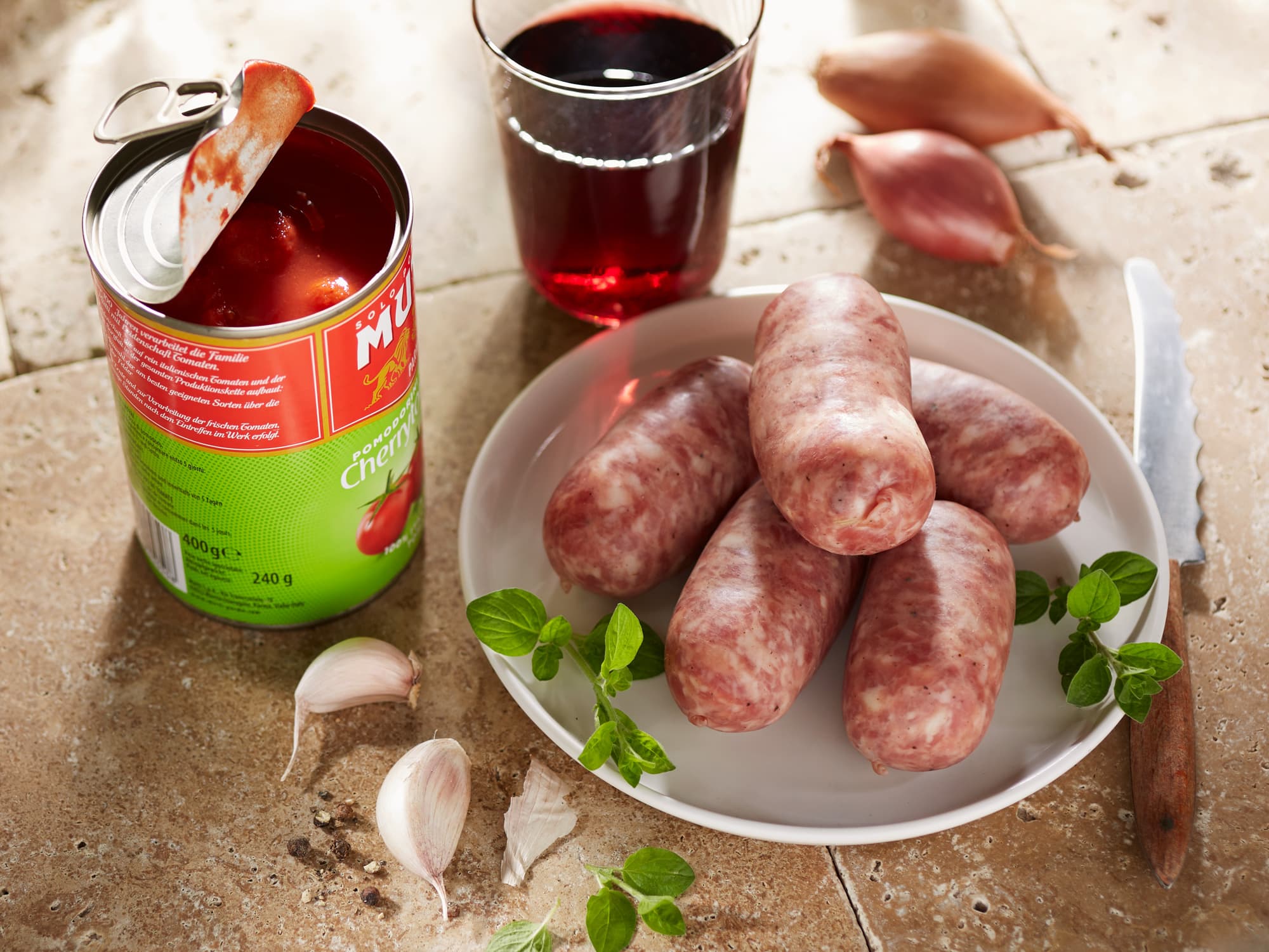 Frische Salsiccia Würste, Dosentomaten, Oregano, Knoblauch und ein Glas Rotwein.