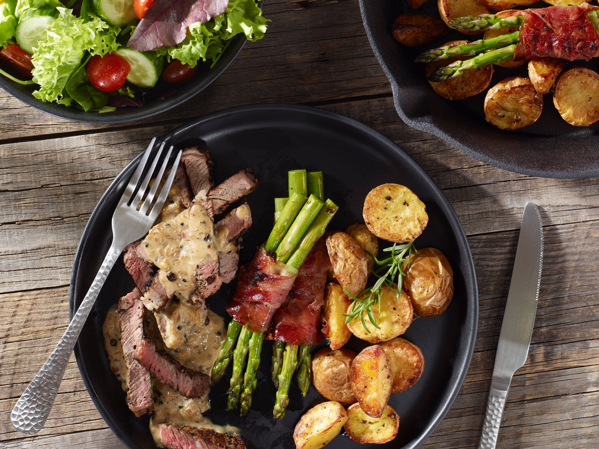Steak au poivre mit grünem Spargel und Rosmarinkartoffeln.