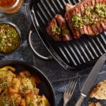 Gebratenes Rumpsteak in Grillpfanne, mit Chimichurri und Smashed Potatoes.