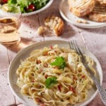 Tagliatelle mit Sahnesauce mit weißem Spargel, gebratenem Speck und frischer Petersilie.